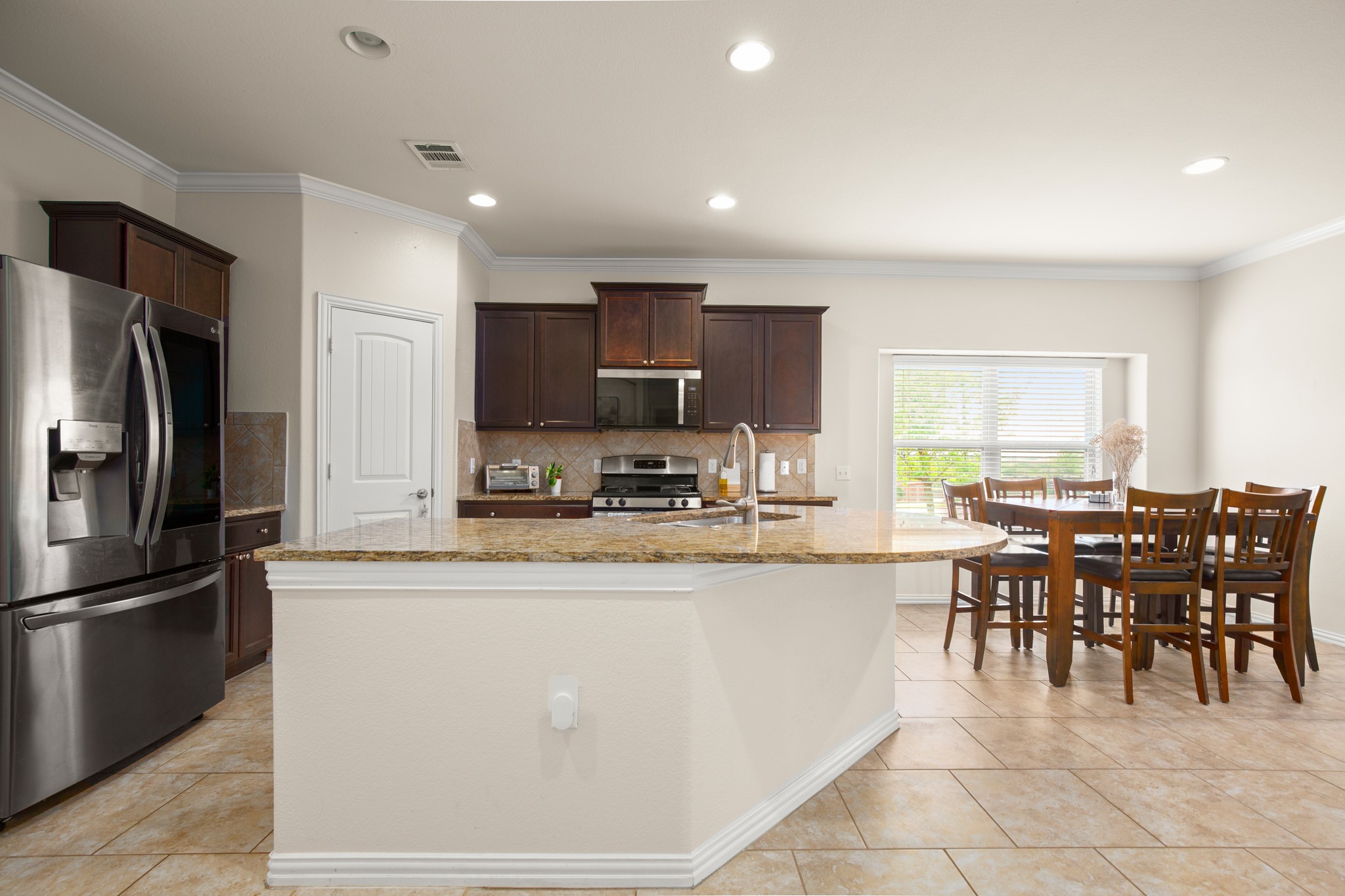10012 Epic Knoll Drive Austin, TX 78747 - Photo 13 of 31 a kitchen with stainless steel appliances granite countertop a refrigerator a stove a sink a dining table and chairs