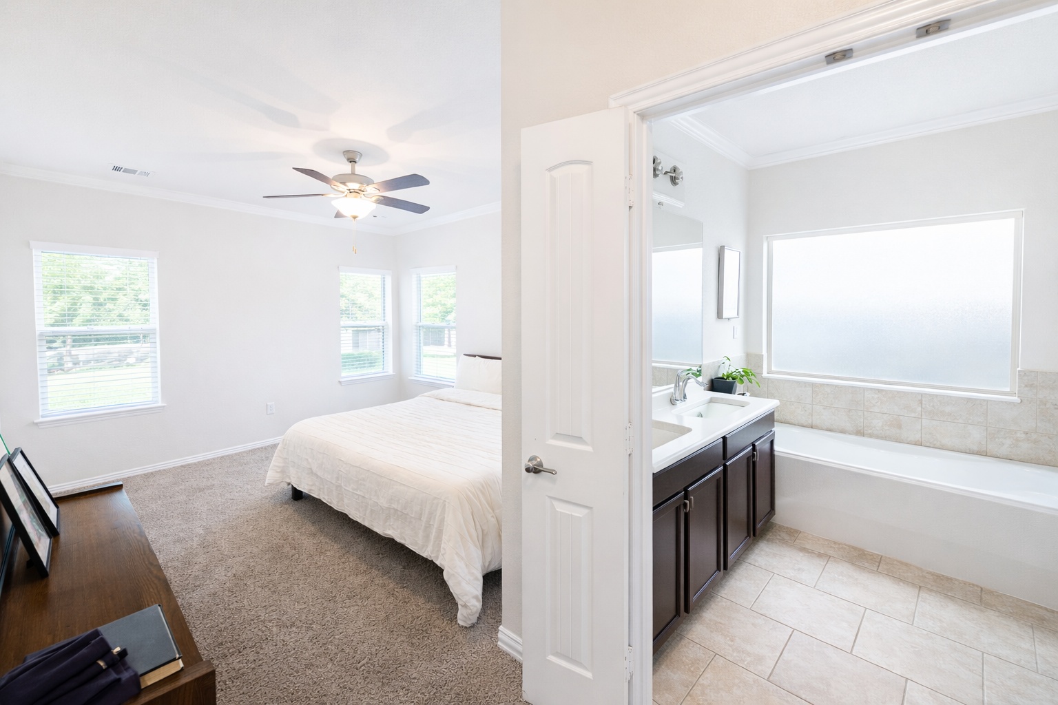 10012 Epic Knoll Drive Austin, TX 78747 - Photo 15 of 31 a spacious bedroom with a bed and a chandelier