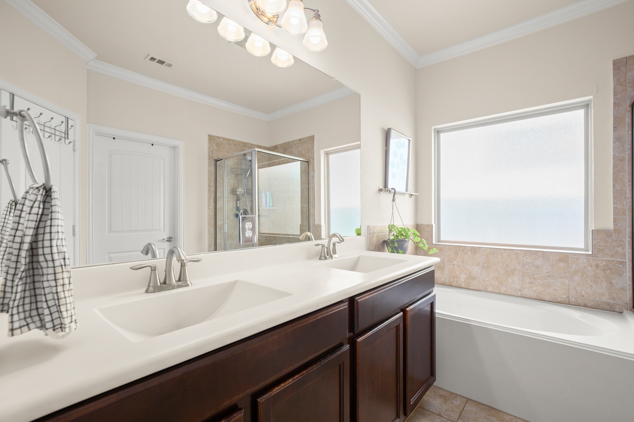 10012 Epic Knoll Drive Austin, TX 78747 - Photo 18 of 31 a bathroom with a sink a large mirror and a bathtub
