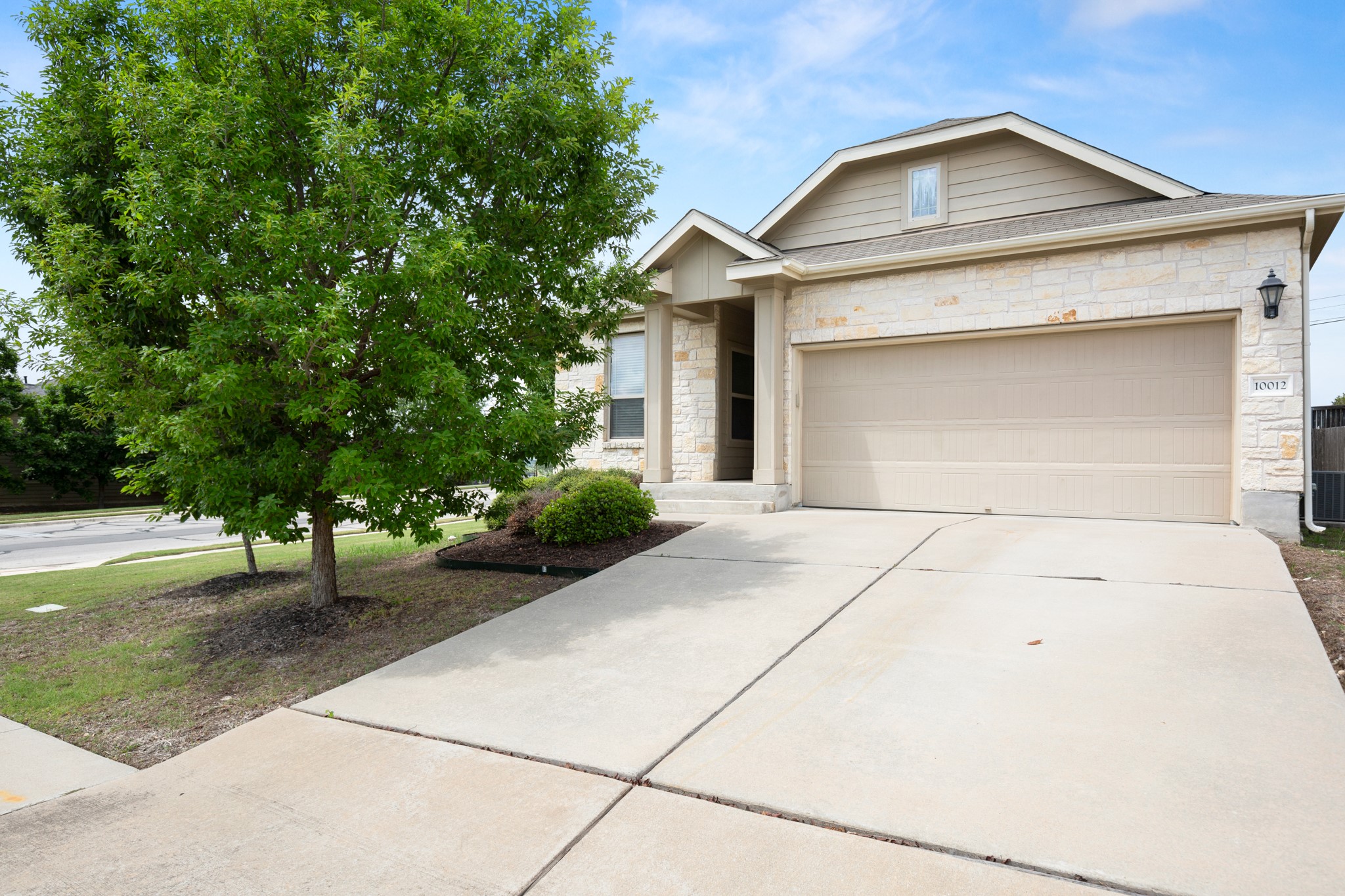 10012 Epic Knoll Drive Austin, TX 78747 - Photo 2 of 31 a front view of a house with a yard and garage