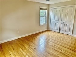 26 Bacon Street, Unit 26 Watertown, MA 02472 - Photo 5 of 12 an empty room with wooden floor and windows