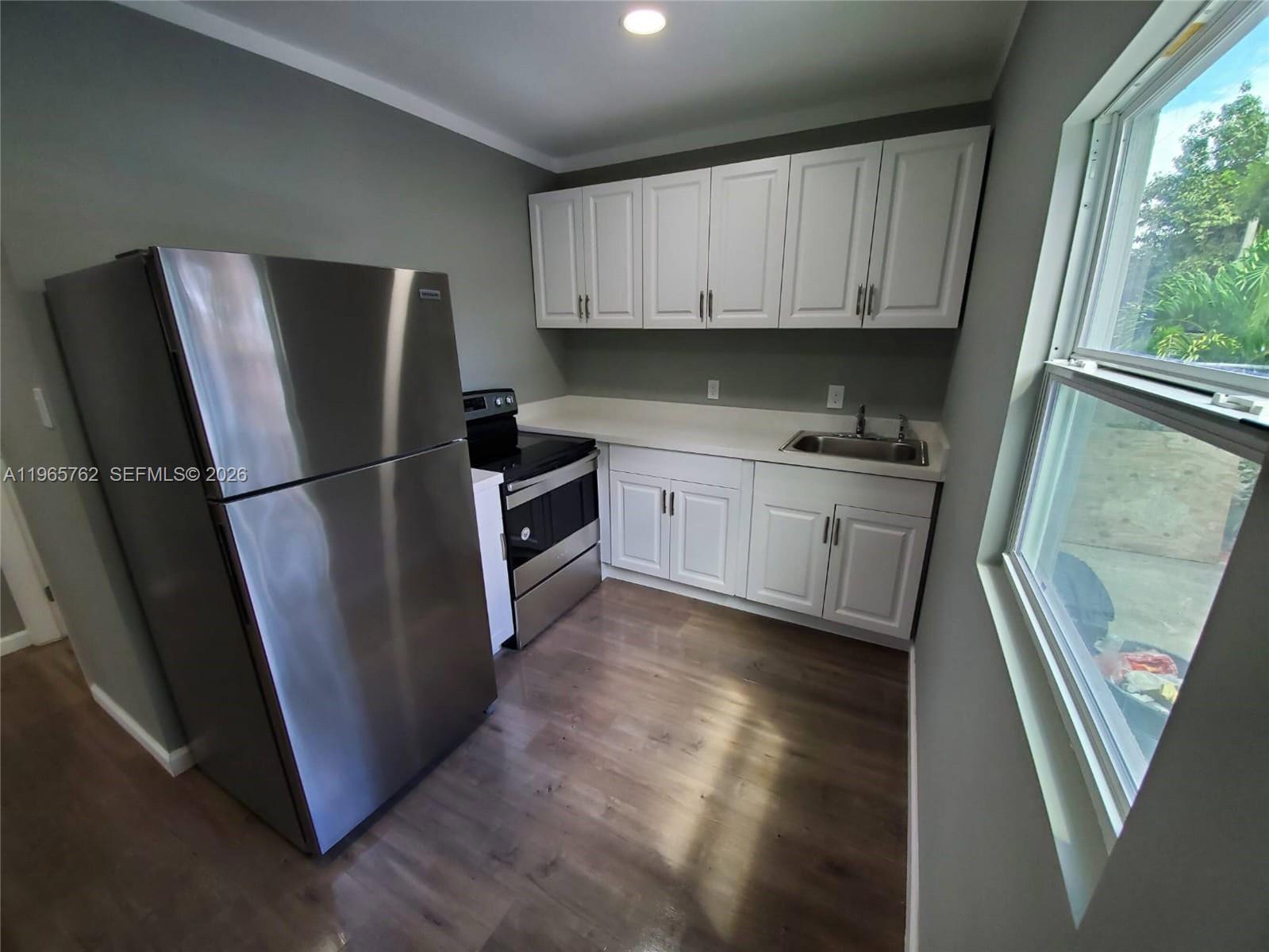 2425 Northwest 28th Street Miami, FL 33142 - Photo 5 of 18 a kitchen with stainless steel appliances granite countertop a refrigerator a sink and a stove