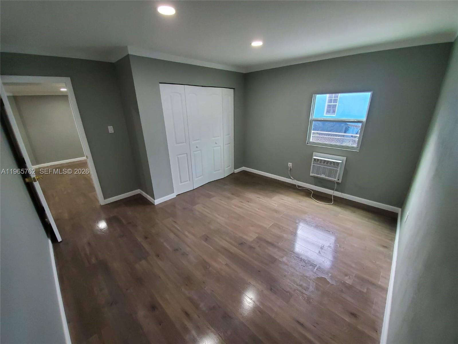 2425 Northwest 28th Street Miami, FL 33142 - Photo 6 of 18 an empty room with wooden floor and windows