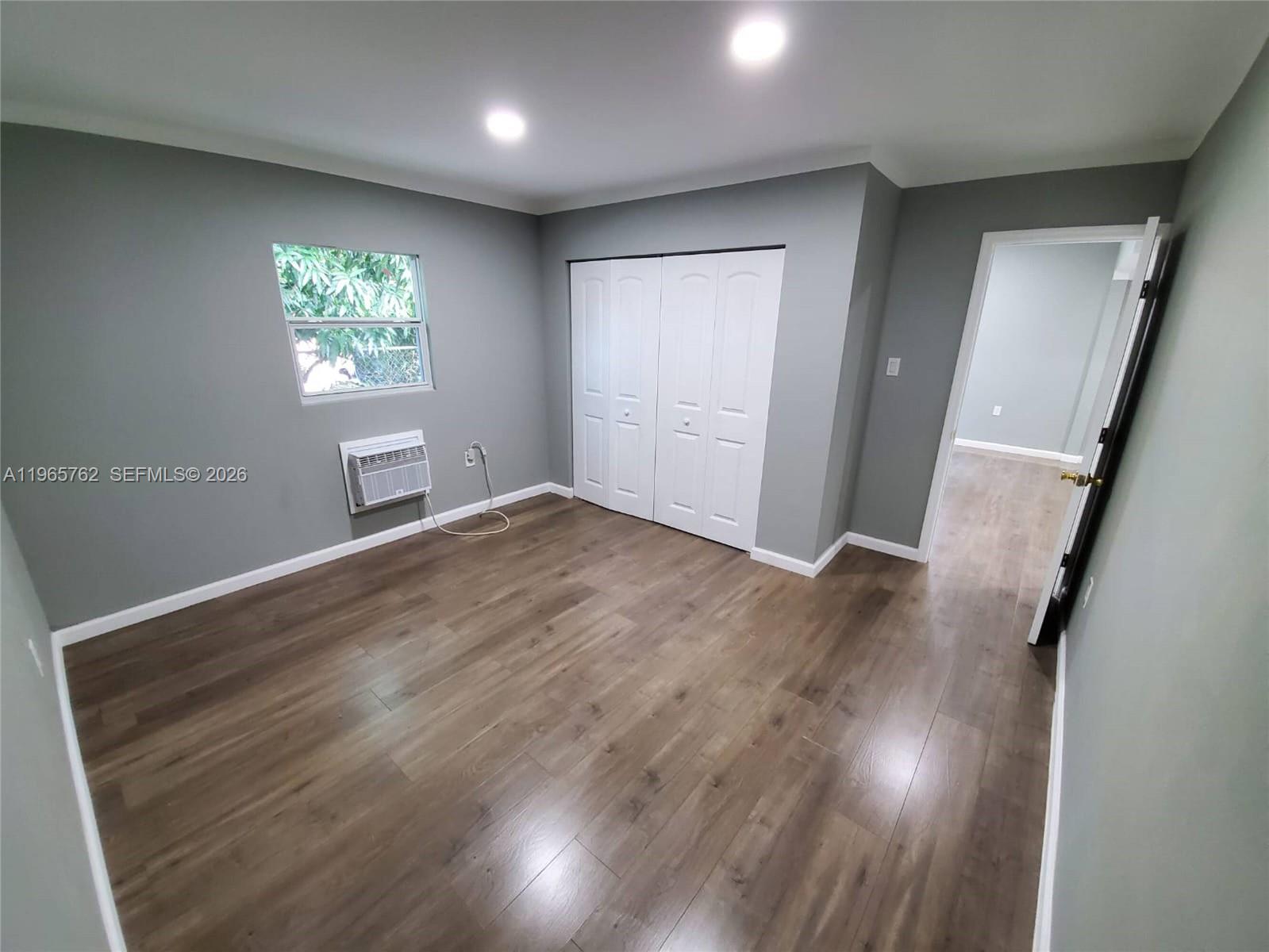 2425 Northwest 28th Street Miami, FL 33142 - Photo 7 of 18 wooden floor in an empty room with a window