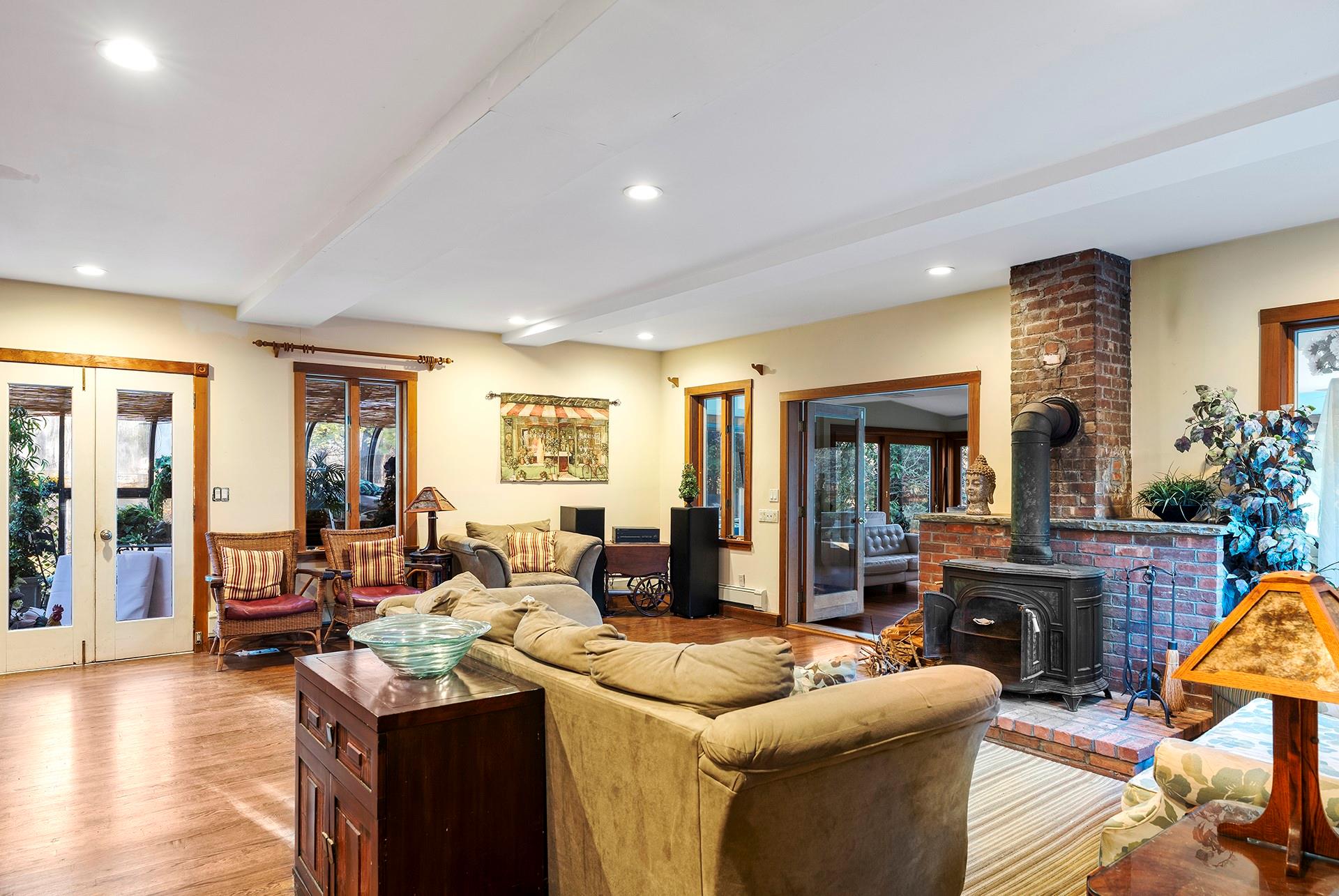 61 Lower 7 Ponds Road Water Mill, NY 11976 - Photo 13 of 43 Living area featuring french doors, beamed ceiling, a wood stove, healthy amount of natural light, and recessed lighting