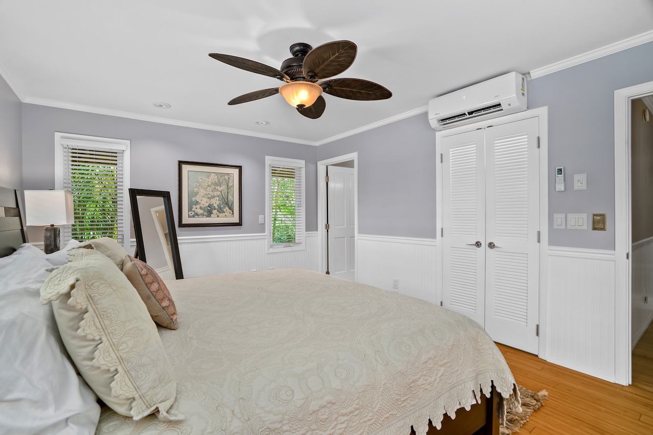 2889 Milo Hae Loop Koloa, HI 96756 - Photo 17 of 27 a bedroom with a large bed and a chandelier