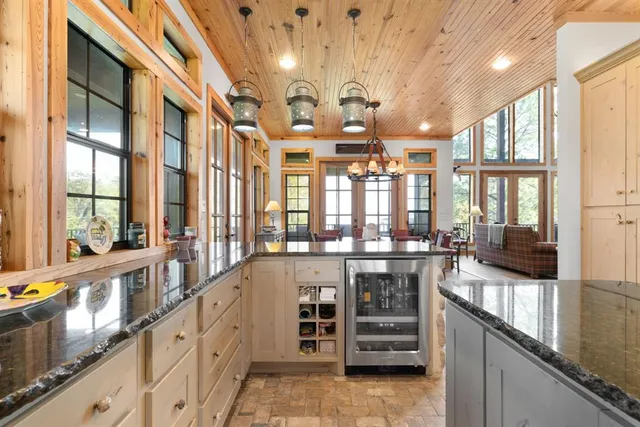 a bedroom with a bed a chandelier and next to a window