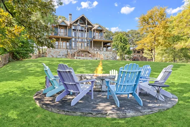 a view of a lake with a table and chairs next to a yard
