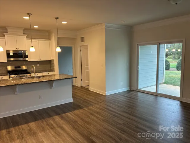 a view of kitchen with granite countertop window and wooden floors