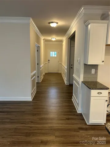 a view of a kitchen with wooden floor and electronic appliances