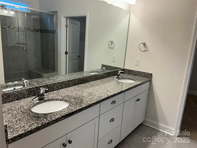 a bathroom with a granite countertop sink double and mirror