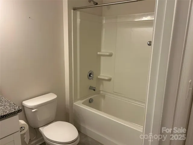a white toilet sitting next to a bath tub