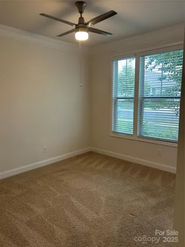 an empty room with a ceiling fan and a window