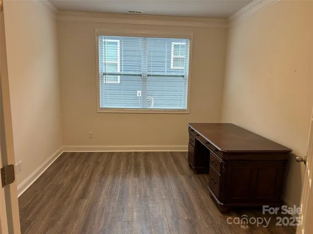 an empty room with a fireplace and wooden floor