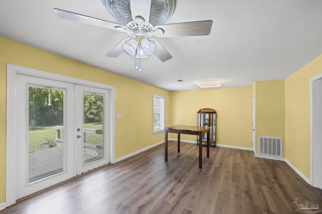 a view of a livingroom with furniture wooden floor a ceiling fan and a window