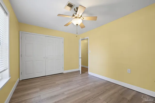 a view of a room with wooden floor and ceiling fan