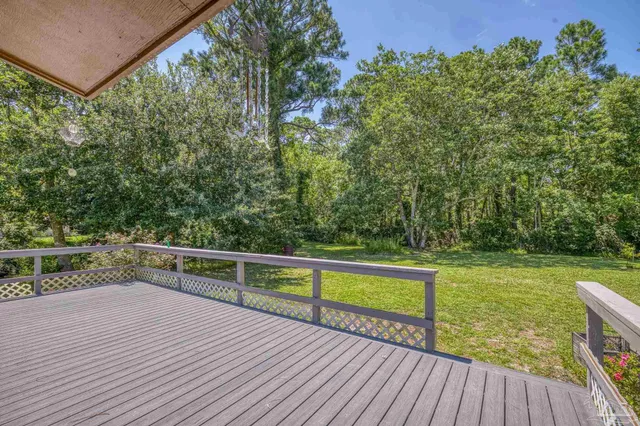 a view of a balcony with wooden floor and fence