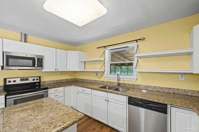 a kitchen with stainless steel appliances granite countertop a sink and a stove