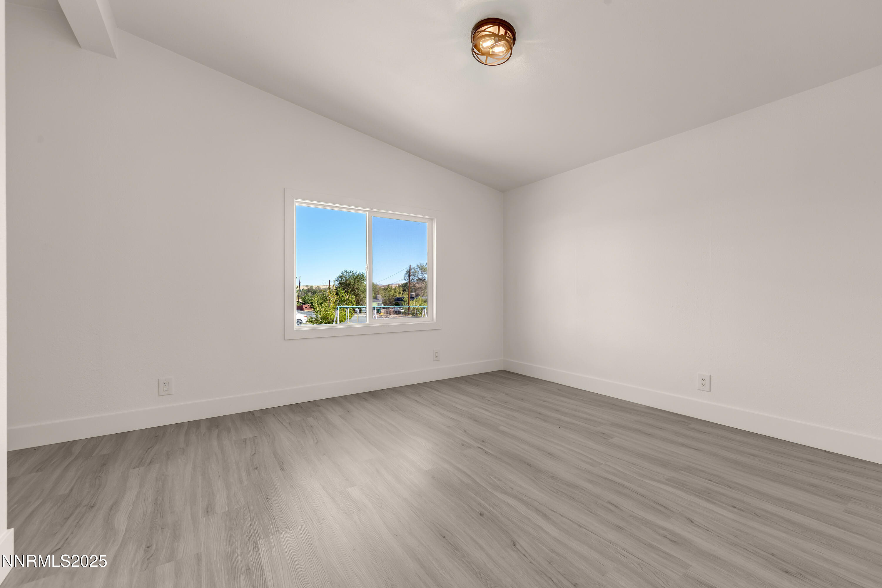 145 Wewoka Way Sun Valley, NV 89433 - Photo 12 of 36 an empty room with wooden floor and window