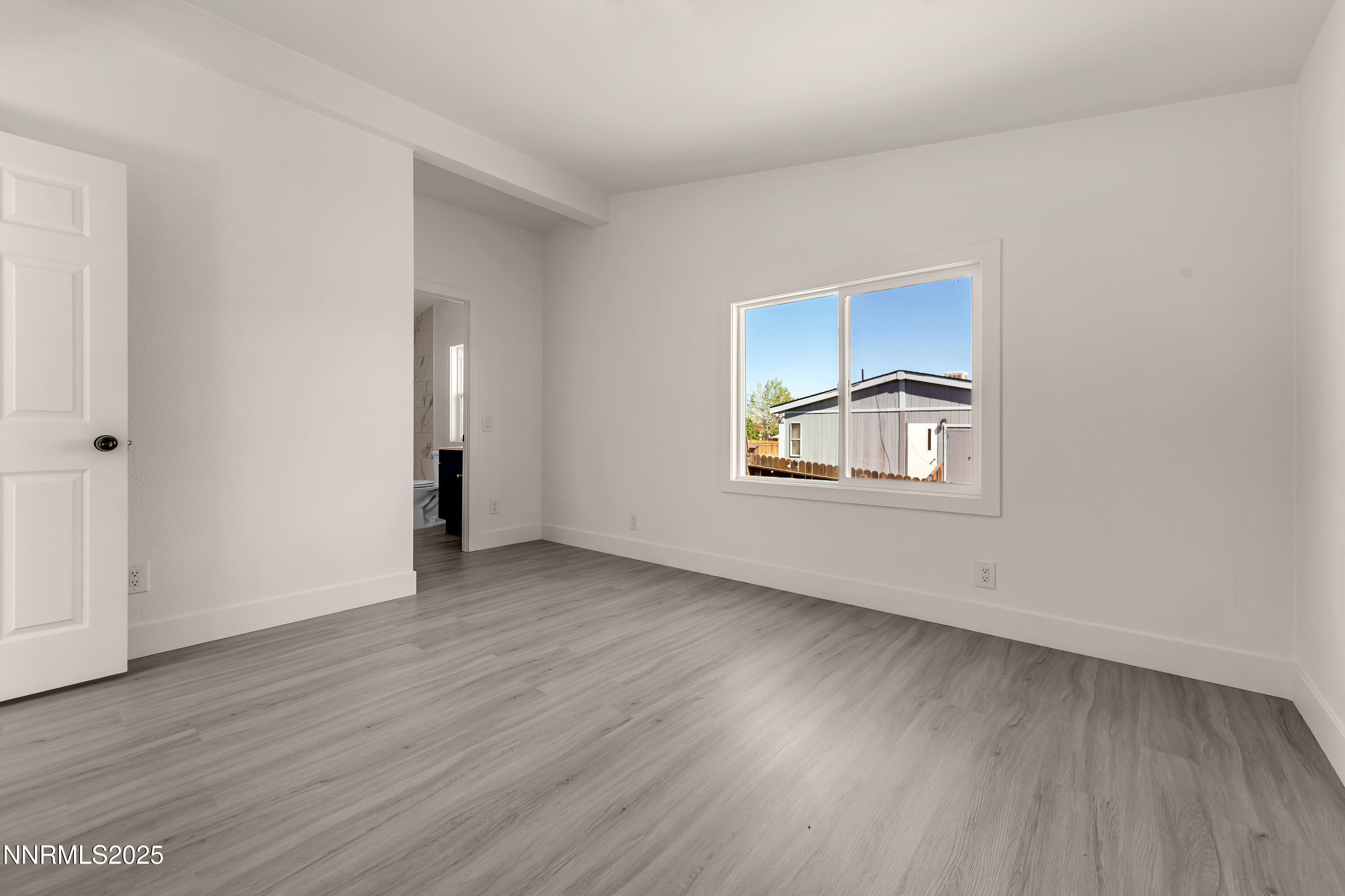 145 Wewoka Way Sun Valley, NV 89433 - Photo 14 of 36 an empty room with wooden floor and windows