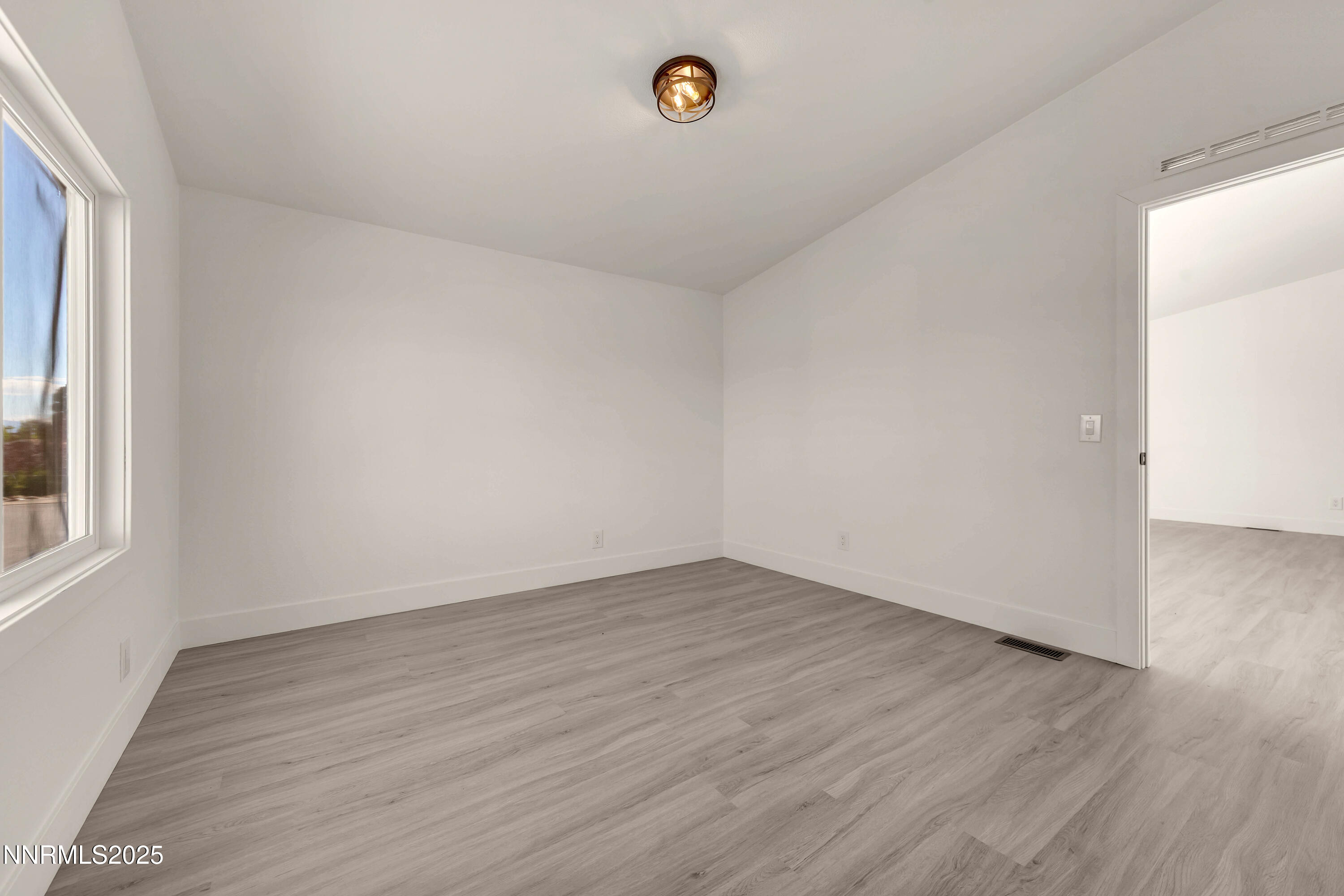 145 Wewoka Way Sun Valley, NV 89433 - Photo 17 of 36 a view of an empty room with wooden floor and a window