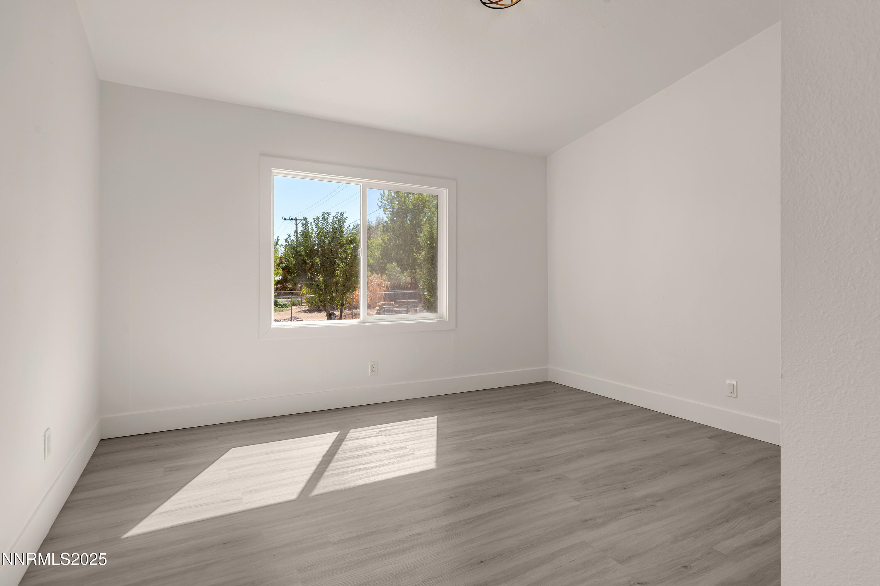 145 Wewoka Way Sun Valley, NV 89433 - Photo 20 of 36 an empty room with wooden floor and windows