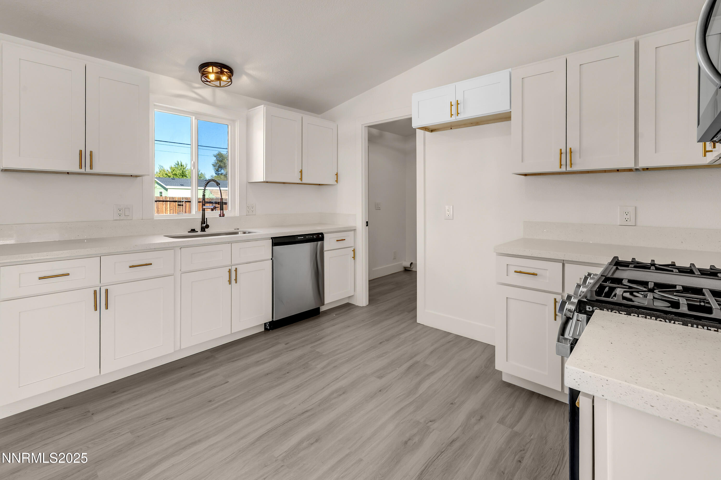 145 Wewoka Way Sun Valley, NV 89433 - Photo 3 of 36 a kitchen with a sink a stove and cabinets