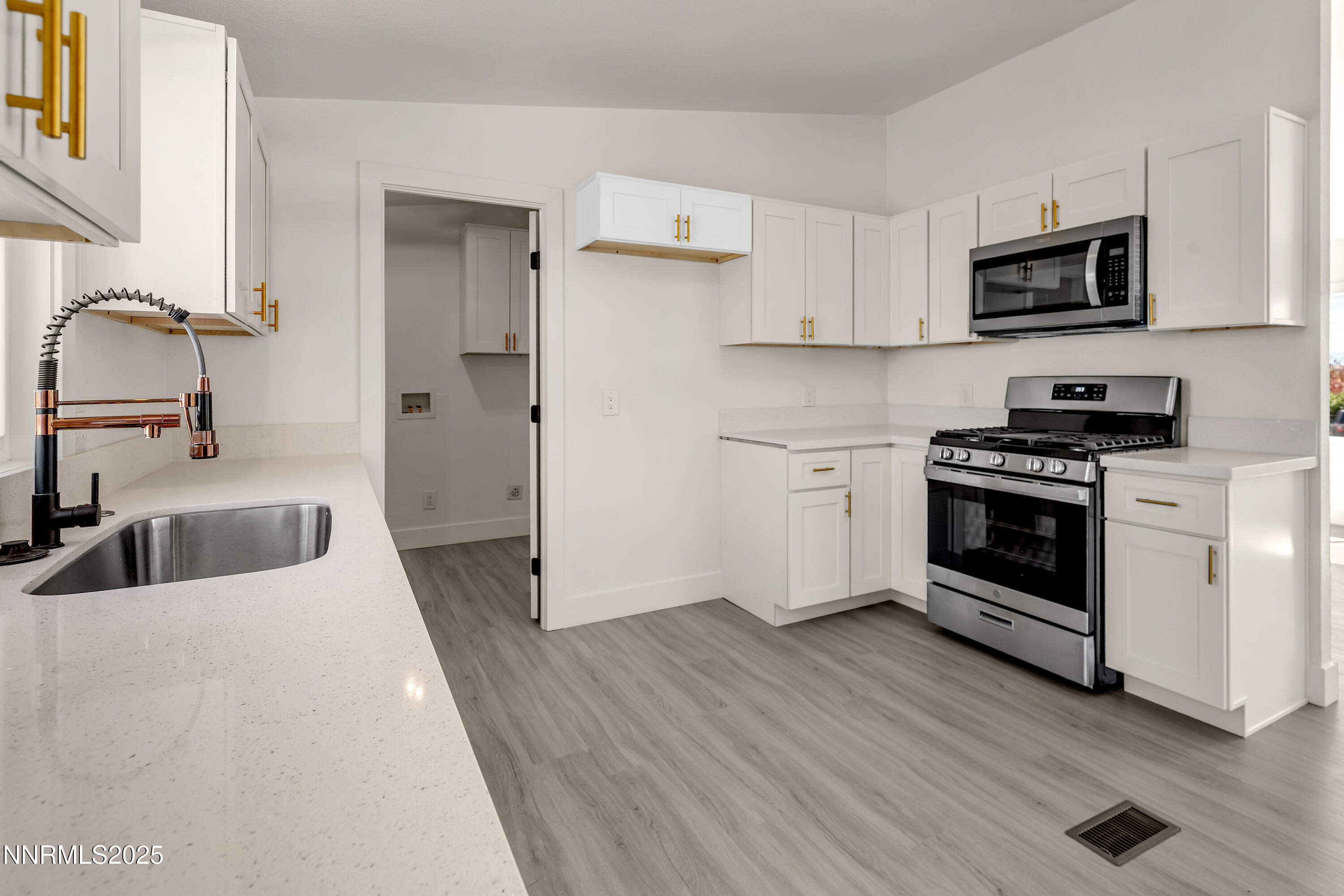 145 Wewoka Way Sun Valley, NV 89433 - Photo 4 of 36 a kitchen with granite countertop a stove and a sink