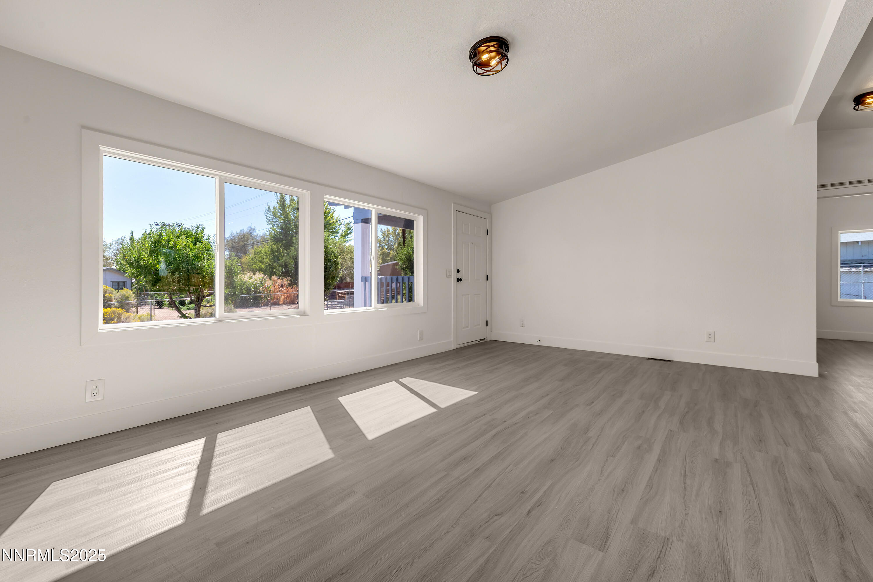 145 Wewoka Way Sun Valley, NV 89433 - Photo 6 of 36 an empty room with wooden floor and windows