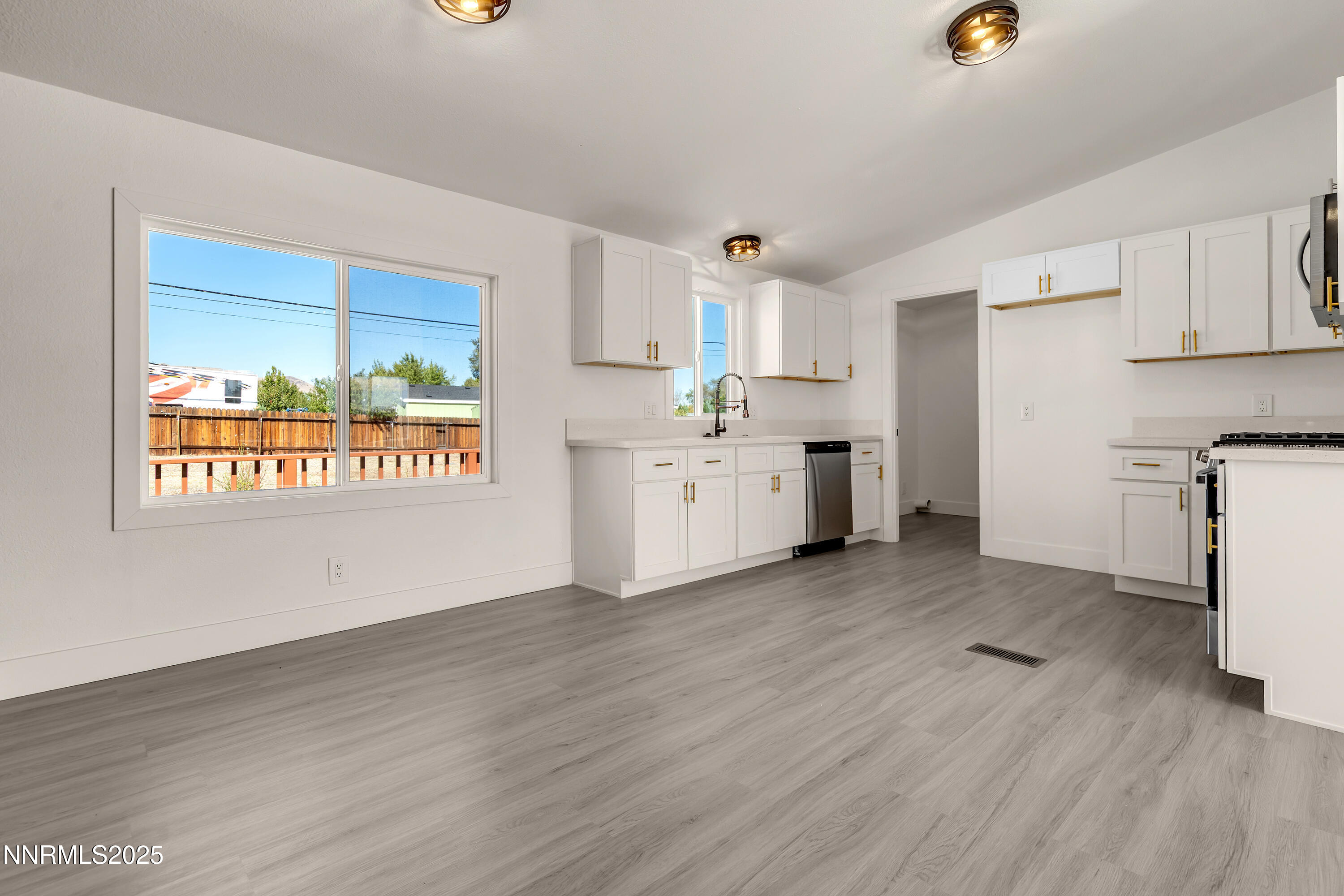 145 Wewoka Way Sun Valley, NV 89433 - Photo 8 of 36 a view of a kitchen with a sink wooden cabinets and a window