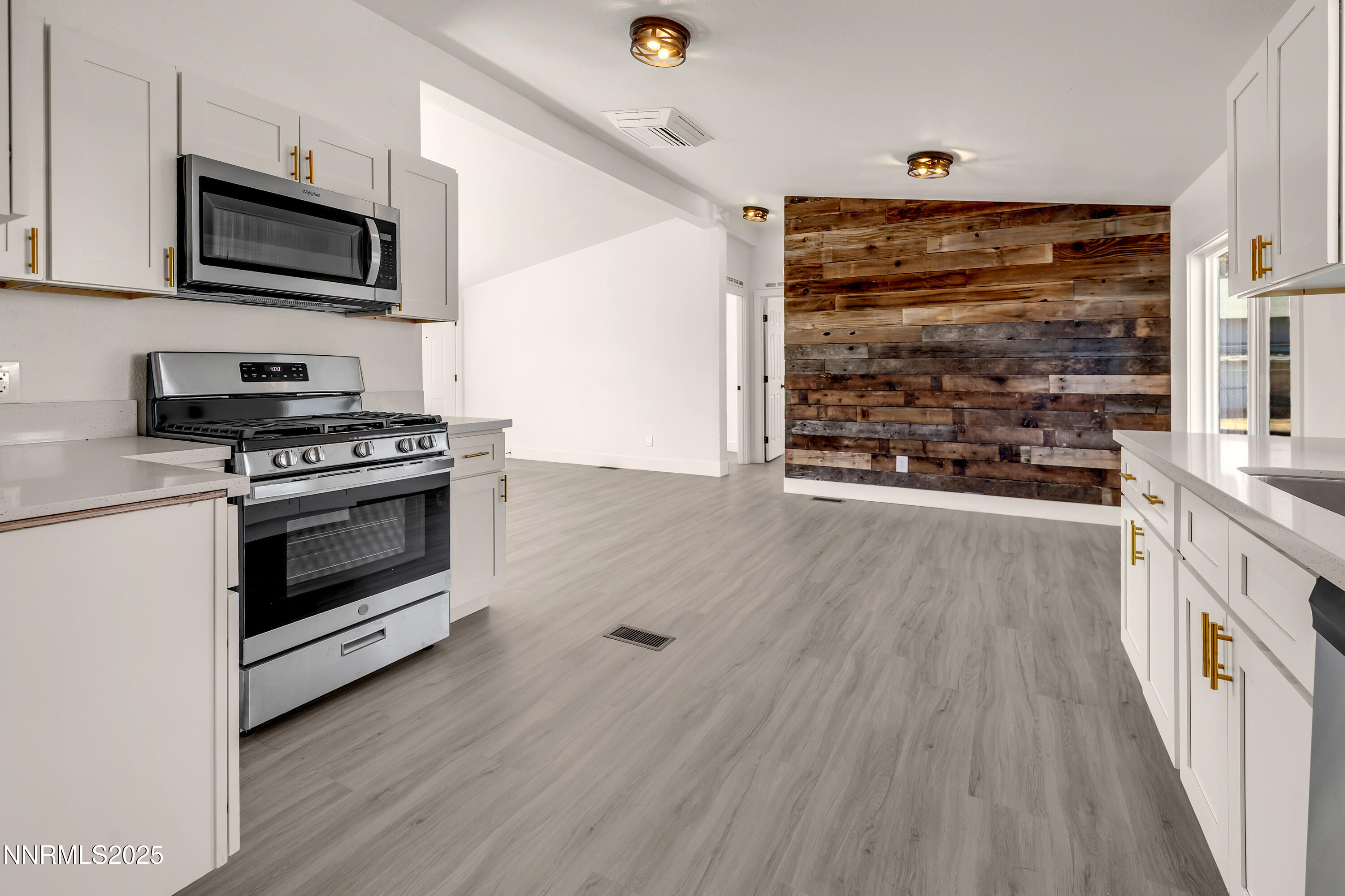 145 Wewoka Way Sun Valley, NV 89433 - Photo 10 of 36 a kitchen with granite countertop a stove and a microwave
