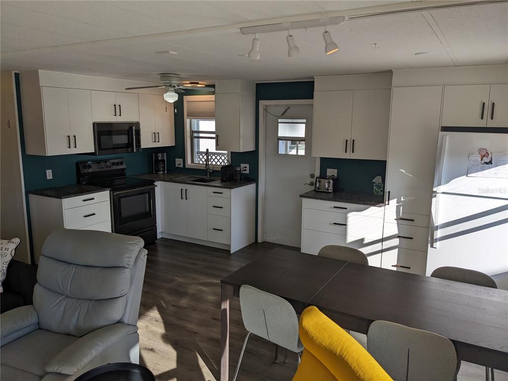 800 32nd Avenue South, Unit 612 St. Petersburg, FL 33705 - Photo 3 of 16 a kitchen with stainless steel appliances kitchen island granite countertop a sink a stove a refrigerator cabinets and chairs