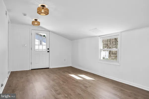 an empty room with windows and wooden floor