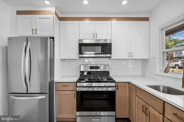 a kitchen with cabinets stainless steel appliances and a counter space