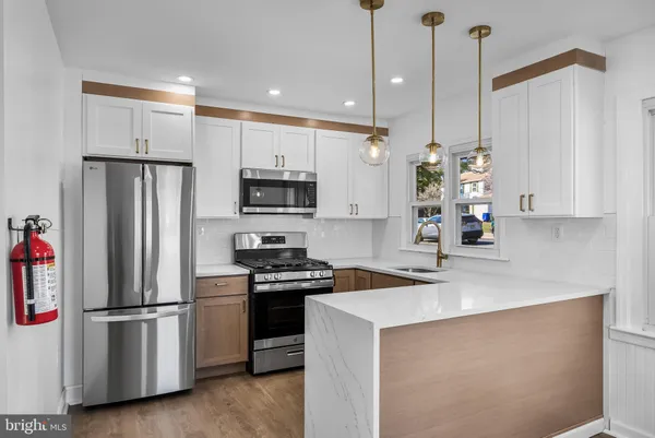a kitchen with stainless steel appliances a refrigerator sink and microwave