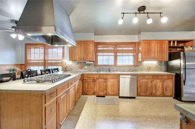 a kitchen with stainless steel appliances granite countertop a refrigerator and a sink