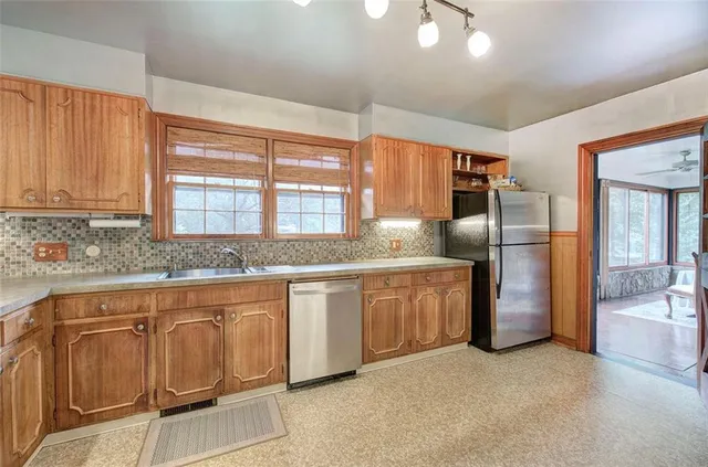 a kitchen with stainless steel appliances granite countertop wooden cabinets a sink and a stove