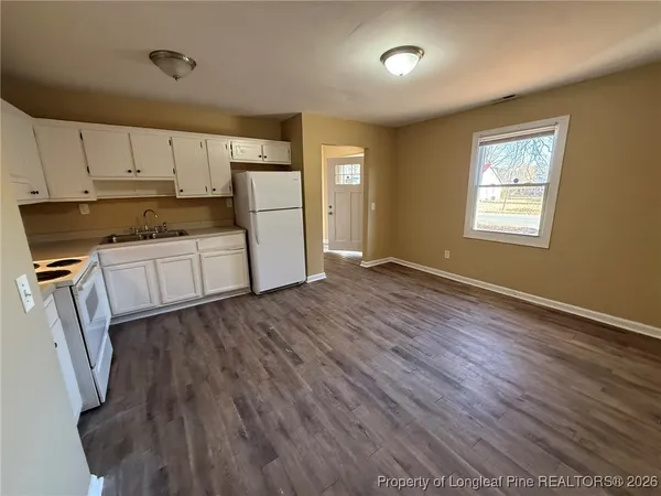 a view of a kitchen with wooden floor and electronic appliances