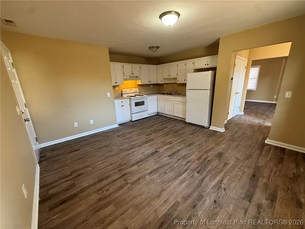 a view of a kitchen with wooden floor and electronic appliances