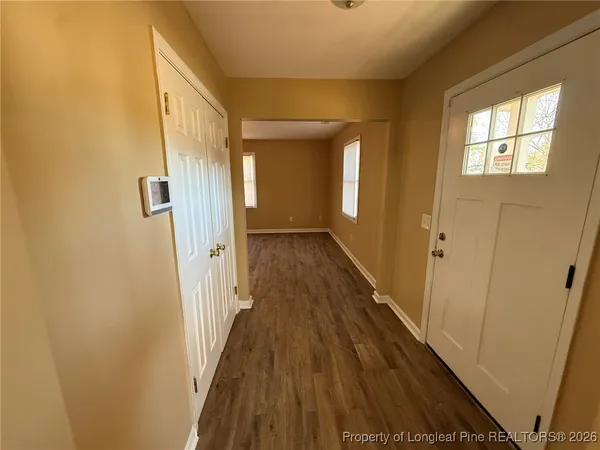 a view of a hallway with wooden floor and staircase