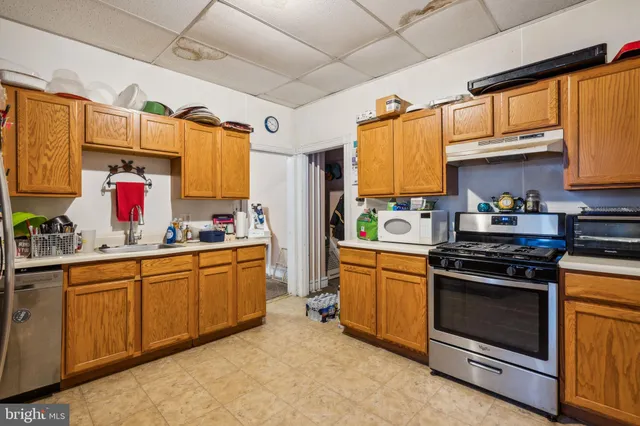 a kitchen with stainless steel appliances granite countertop a sink a stove a refrigerator and cabinets