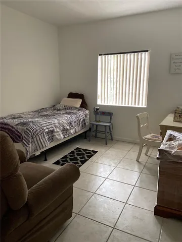 a bedroom with a bed a rug and a dresser