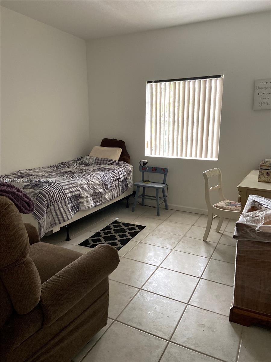 4802 Washington Street, Unit 14 Hollywood, FL 33021 - Photo 3 of 14 a bedroom with a bed a rug and a dresser