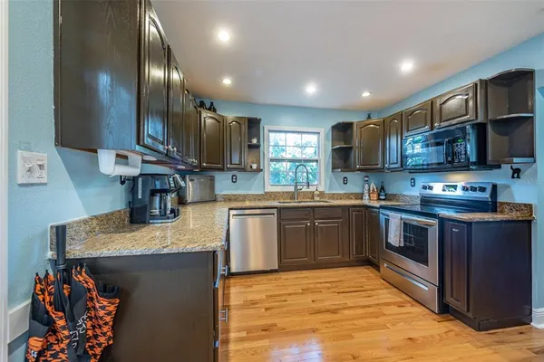 a kitchen with stainless steel appliances granite countertop a sink stove and refrigerator