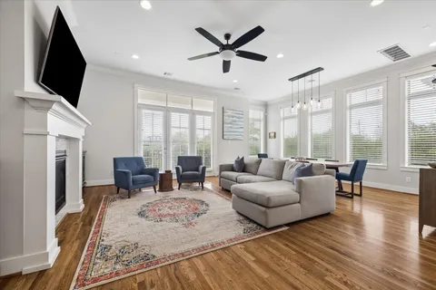 a living room with furniture flat screen tv and a large window