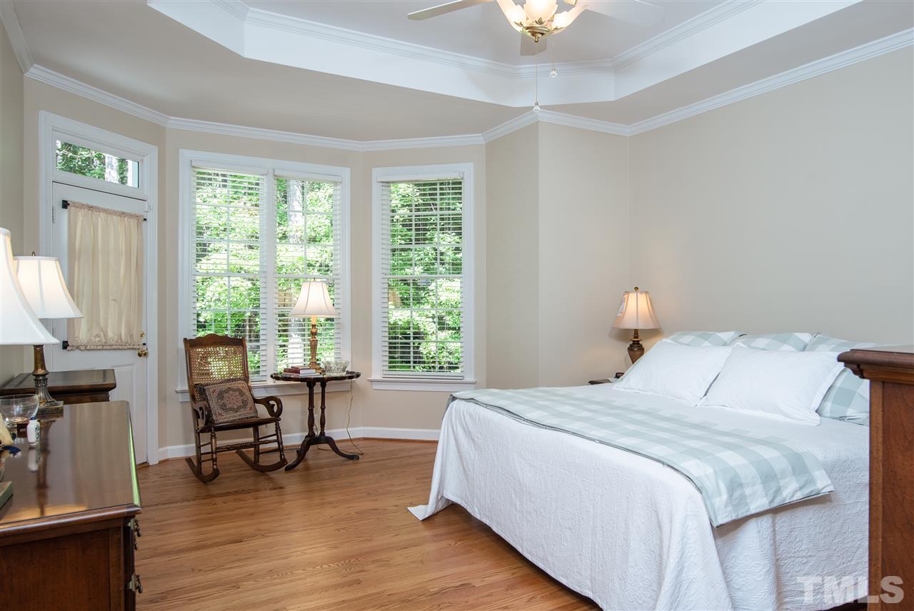 5817 Orchid Valley Road Raleigh, NC 27613 - Photo 12 of 25 a bedroom with a bed a table and a chandelier