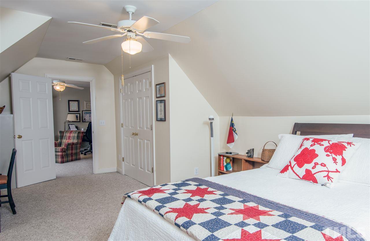 5817 Orchid Valley Road Raleigh, NC 27613 - Photo 17 of 25 a bedroom with a bed and a chandelier