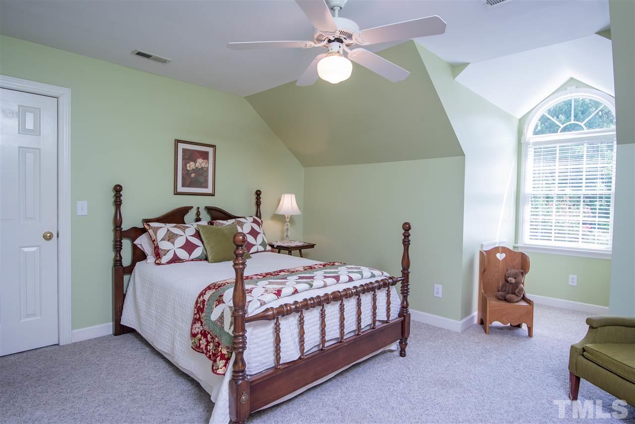 5817 Orchid Valley Road Raleigh, NC 27613 - Photo 20 of 25 a bedroom with a bed a chandelier and a dresser