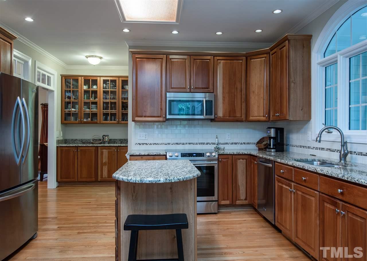 5817 Orchid Valley Road Raleigh, NC 27613 - Photo 9 of 25 a kitchen with stainless steel appliances granite countertop a refrigerator sink and cabinets