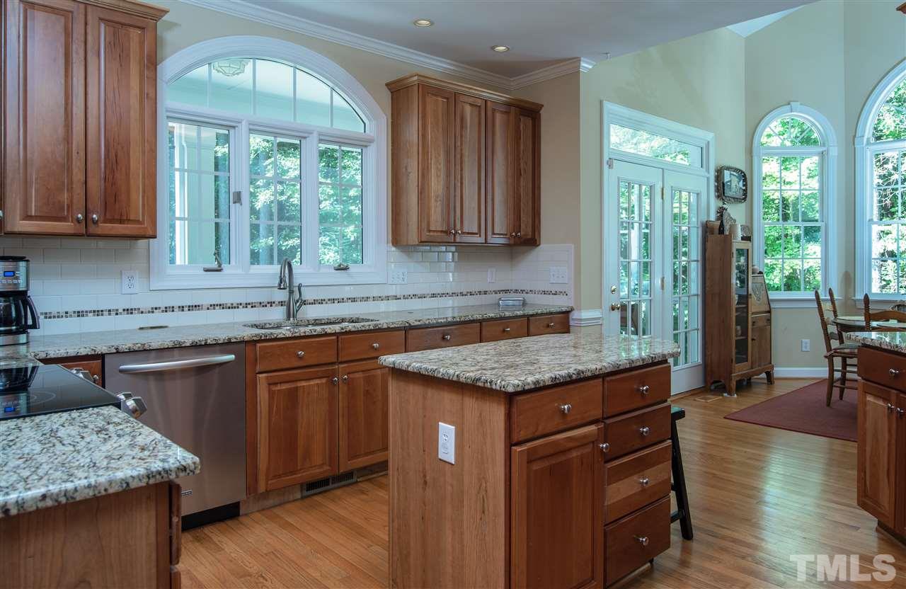5817 Orchid Valley Road Raleigh, NC 27613 - Photo 10 of 25 a kitchen with stainless steel appliances granite countertop wooden floors and sink